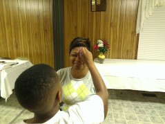One of the kids draws on Ms. Katisha's face for the activity